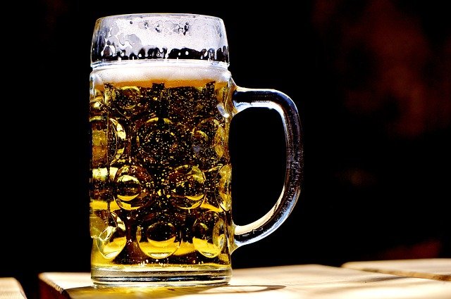 Stein full of beer on table top.