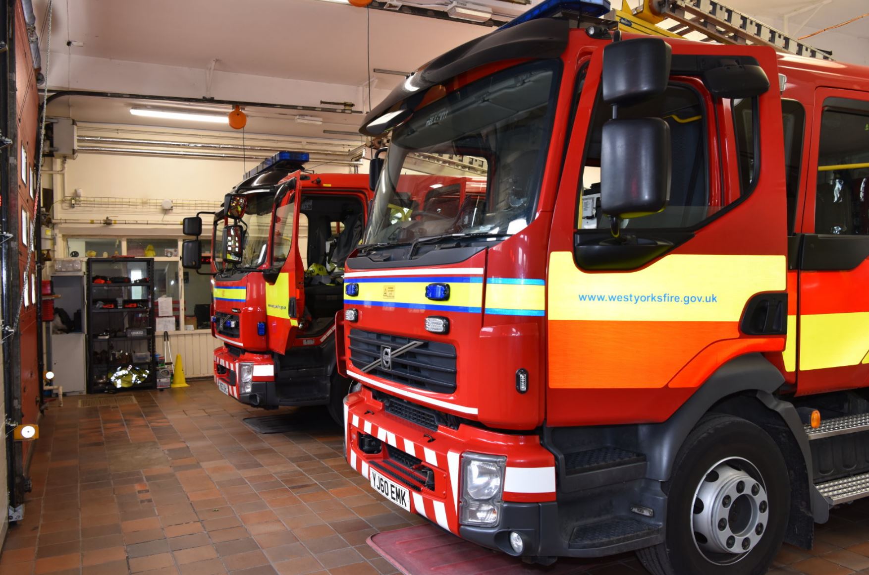 Two fire engines parked up in a fire station.