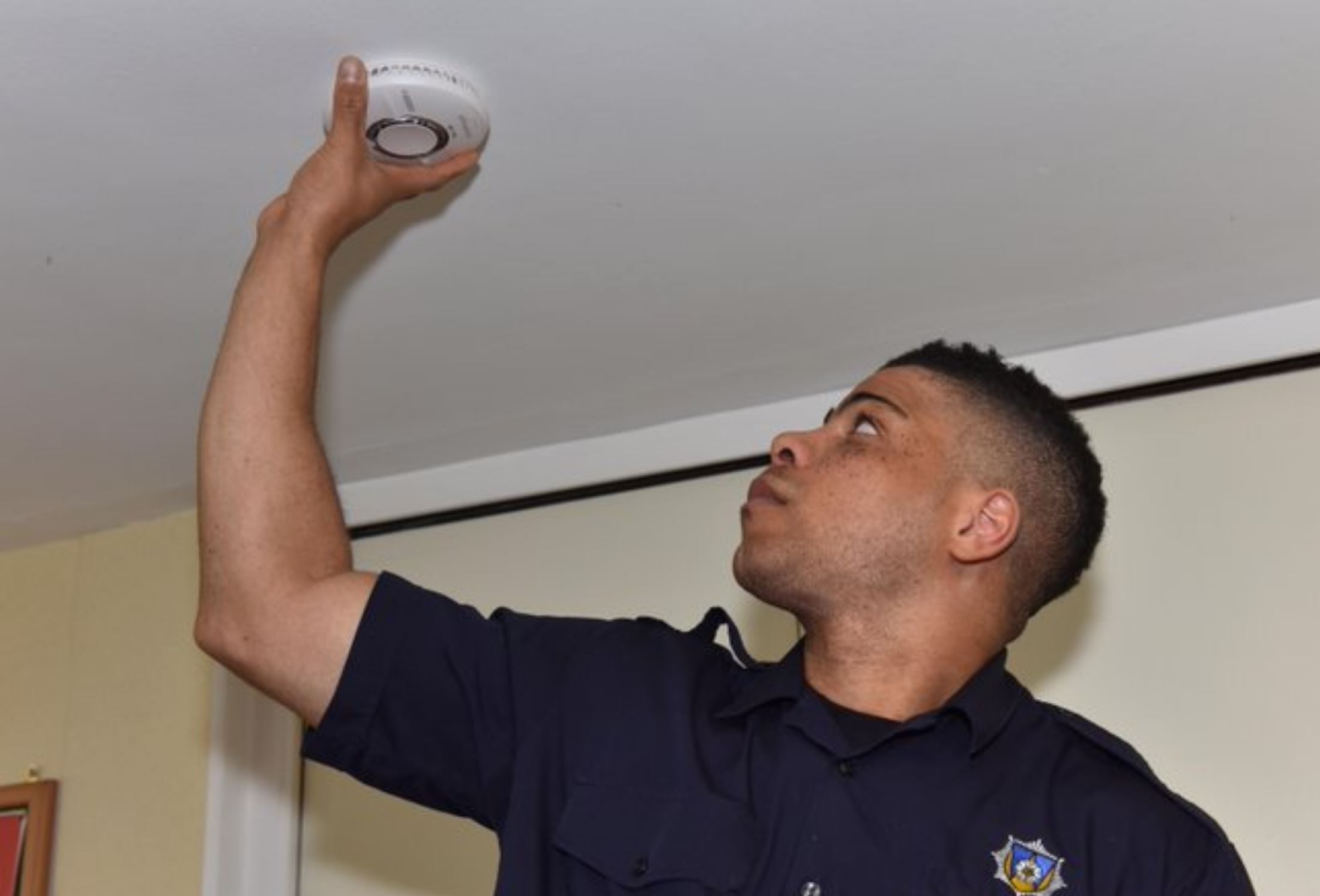 Firefighter fitting smoke alarm. 