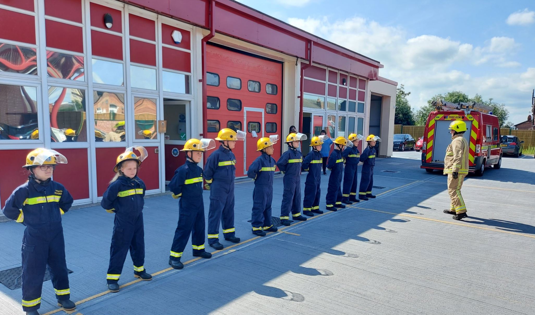 Line of youth interventions team members in front of fire station. 