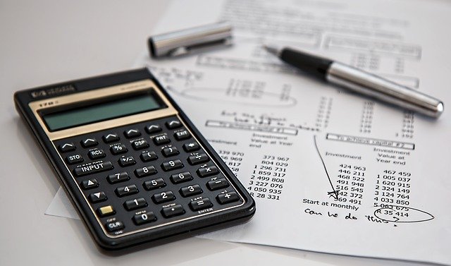 Calculator and pen on paper with accounts information. 