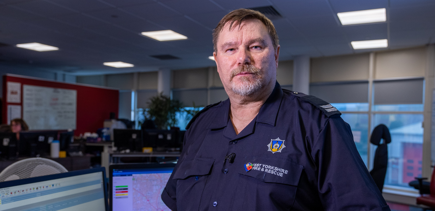 Control Manager Mark Thompson stood in-front of computers in WYFRS uniform