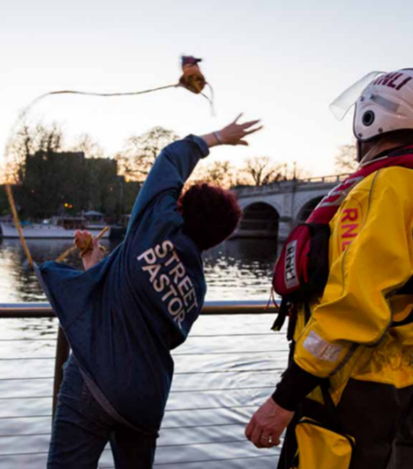 Street patrol throwing throw line into water