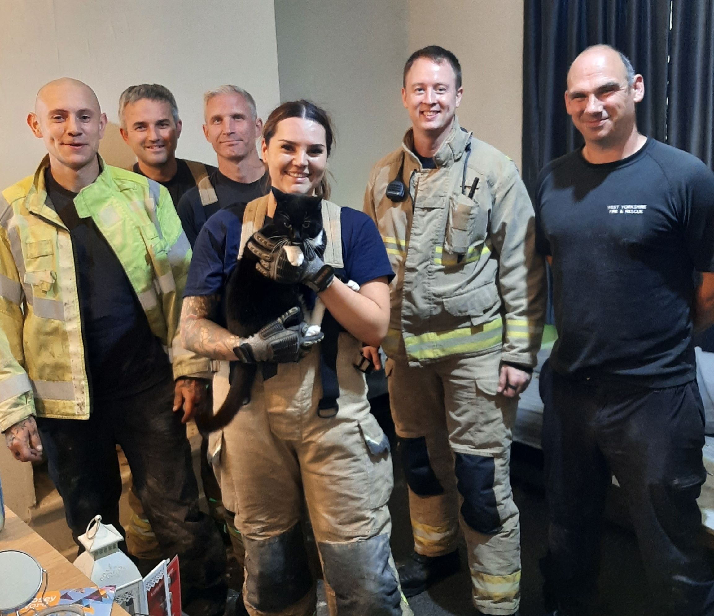 Crew group photo holding black cat