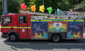 Fire engine with Fire Pride painting on the side and colorful balloons on top. 