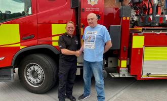 Wakefield Green Watch, Craig Pickles, and Mr Whittaker standing in front of a fire aerial ladder platform