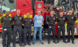 Wakefield Green Watch and Mr Whittaker standing in front of a fire aerial ladder platform