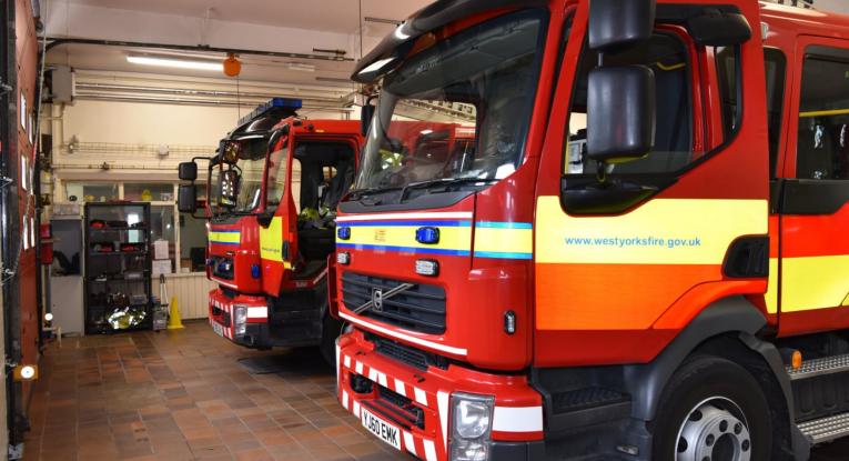 Two fire engines parked up in a fire station.