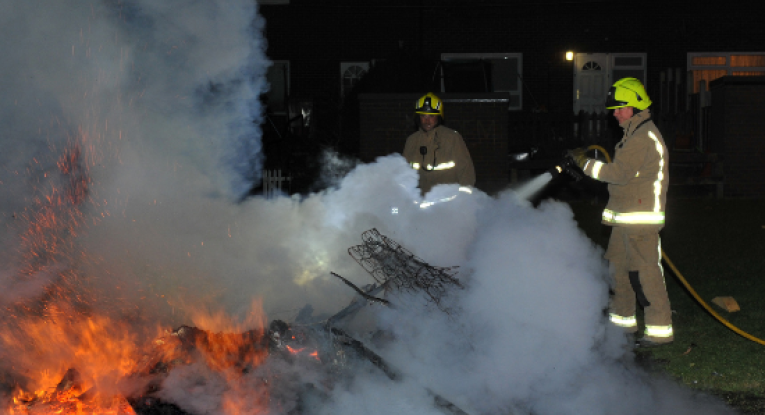 Firefighters attending to out of control bonfire